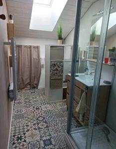 a bathroom with a tile floor and a sink at La chambre CHAT,au coeur des Vosges in Ferdrupt