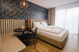 um quarto de hotel com uma cama e uma mesa em Rioca Stuttgart Posto 6 em Estugarda