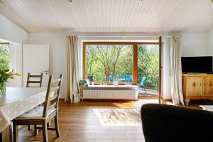 a living room with a table and a large window at Ferienhaus 'kiek op de Beek' in Langballig