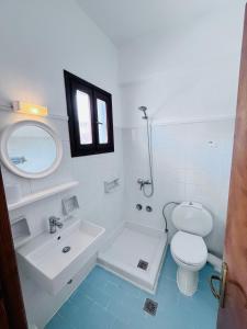 W łazience znajduje się toaleta, umywalka i lustro. w obiekcie Beach House I&II w mieście Alikes