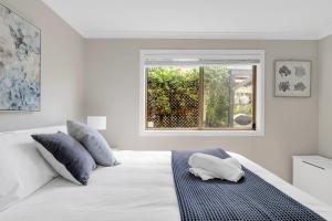 1 dormitorio con 1 cama blanca y ventana en 3-Bed with Beach Views and Entertainment Area, en Surf Beach