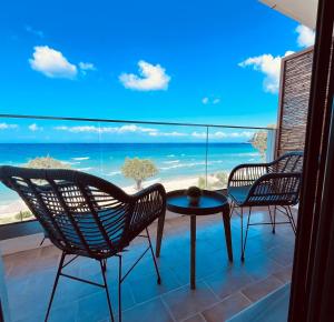 a balcony with chairs and a table and a view of the ocean at Beach House I&II in Alykes