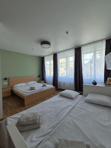 a large bedroom with two beds and windows at Elīna in Jūrmala