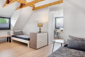 a bedroom with a bed and a desk and two windows at Casa Caso - Apartment 5 in Achim