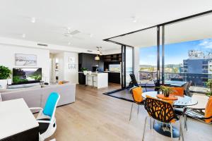een woonkamer met een bank en een tafel en stoelen bij 5th Floor Beachside Ocean View with Wi-Fi, Pool and Gym in Gold Coast