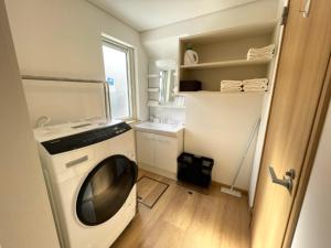 a laundry room with a washing machine and a window at 【ペット可】Niseko STREAM Villas in Rankoshi