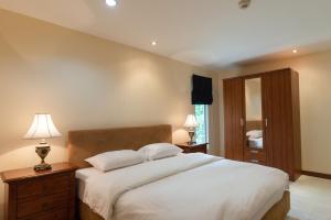 una camera da letto con un grande letto bianco con due cuscini di Jomtien Beach Residence a Jomtien Beach Altre 40 foto