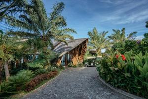 a house surrounded by palm trees and plants at Elevate Bali in Munduk