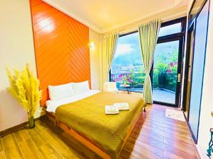 1 dormitorio con cama y ventana grande en Be Youth Villa Đà Lạt, en Da Lat