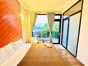 una camera con un letto e una grande finestra di Be Youth Villa Đà Lạt a Da Lat
