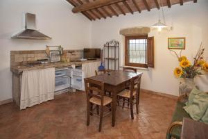 a kitchen with a wooden table and a dining room at Agriturismo Poggio delle Conche in Pitigliano
