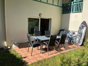 una mesa de comedor y sillas en un patio con bicicletas en appartement T3 Soustons plage Vieux Boucau océan, en Soustons