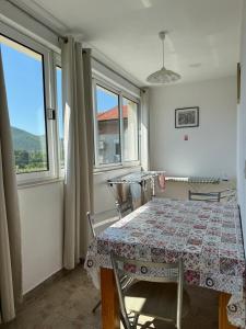 a dining room with a table and two windows at Pansion Ivanka Barac in Međugorje