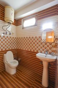 a bathroom with a toilet and a sink at Luvya Retreats Hotel in Manāli