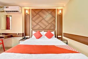 a bedroom with a large bed with red pillows at OYO Hotel Star Ldh in Ludhiana