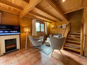 ein Wohnzimmer mit einem Kamin in einer Blockhütte in der Unterkunft Chalet Pura Vida Morillon Samoëns Grand Massif 6-8 in Morillon