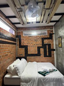 马六甲BabagoT877的一间有砖墙的房间里的一张床
