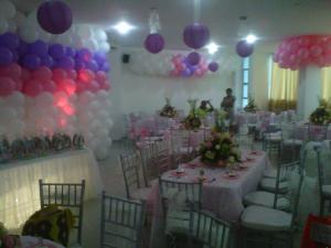 een kamer met een tafel, stoelen en ballonnen bij Hotel Tropical in Corozal