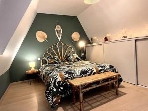 ein Schlafzimmer mit einem Bett und einer Bank darin in der Unterkunft VILLA 10 PERSONNES AVEC PISCINE PRIVATIVE PROCHE SARLAT in Beynac-et-Cazenac