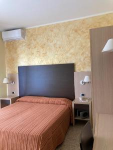 Schlafzimmer mit einem großen Bett mit blauem Kopfteil in der Unterkunft Hotel Promenade in Porto SantʼElpidio