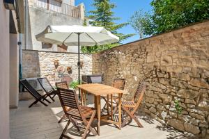 a table and chairs with an umbrella on a patio at Arassa casa rural in Rocafort de Queralt