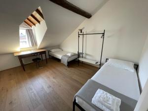 a bedroom with a bed and a desk in a attic at Design Apartment in the heart of Bolzano in Bolzano