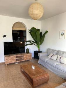 ein Wohnzimmer mit einer Couch und einem Couchtisch in der Unterkunft Casa Buganvilla con piscina en San José Sotillo in San José