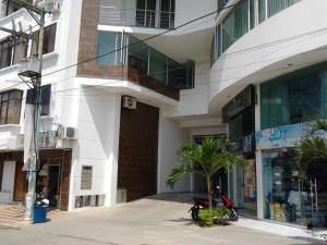 a building with a palm tree in front of a building at Hotel Tropical in Corozal