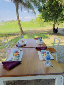 einem Holztisch mit Schalen mit Obst und Wasser darauf in der Unterkunft Harmony Haven Eco Camp, Udawalawa in Udawalawe
