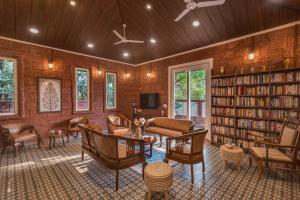 ロナバラにあるSaffronStays Chira - Pool Villa In The Heart Of Khandalaのリビングルーム(本棚付きライブラリあり)