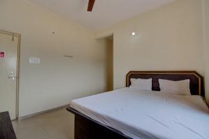 una camera con letto e lenzuola bianche di SPOT ON R D Homestay 1 a Dispur