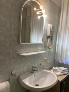 ein Bad mit einem Waschbecken und einem Spiegel in der Unterkunft Hotel Promenade in Porto SantʼElpidio