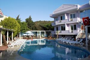 una piscina frente a un edificio con sillas en Cundavilla Hotel & Suites, en Ayvalık