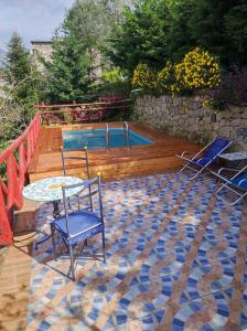 eine Terrasse mit einem Tisch, Stühlen und einem Pool in der Unterkunft Giardino 21 Marzo in Vico Equense