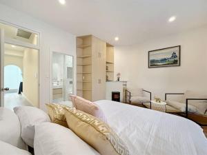 a white bedroom with a large bed and a couch at Sydney CBD Newly Renovated Large Terrace in Sydney