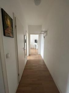 einen Flur mit weißen Wänden und Holzböden in der Unterkunft Wohnung in Köln in Köln