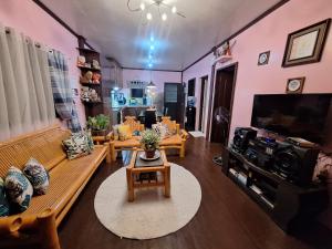 a living room with a couch and a tv at Island samal overlooking view house with swimming pools in San Antonio