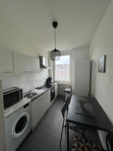 a kitchen with a table and a washing machine at Wohnung in Köln in Cologne