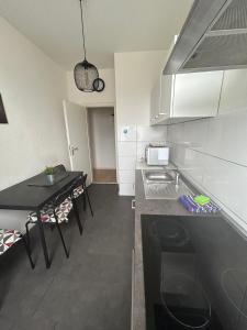 uma pequena cozinha com um balcão preto e uma mesa em Wohnung in Köln em Colónia