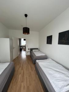 Habitación con 3 camas y lámpara de araña. en Wohnung in Köln en Colonia