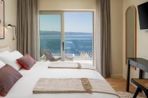 a hotel room with two beds and a large window at New! Casa GENI-heated pool, 3 bedrooms, sea views in Omiš +57 photos