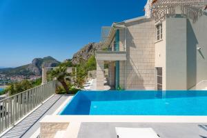 a villa with a swimming pool and a mountain at New! Casa GENI-heated pool, 3 bedrooms, sea views in Omiš