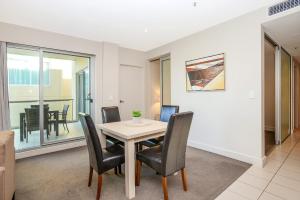 ein Esszimmer mit einem Tisch und Stühlen in der Unterkunft Pier Apartment - Glenelg Views - No 506 in Adelaide