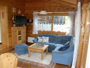 een woonkamer met een blauwe bank en een tafel bij Schanzer-Hütte Comfortable holiday residence in Hohentauern