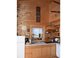 een keuken met houten kasten, een wastafel en een koelkast bij Schanzer-Hütte Comfortable holiday residence in Hohentauern