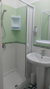 y baño blanco con lavabo y ducha. en Benvenuti al Sud B&B, en Macari