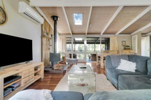 a living room with a couch and a flat screen tv at Secluded 3-Bed Retreat Moments to the Beach in Surf Beach