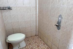 uma casa de banho com um WC e uma parede em azulejo em OYO 93912 Kost Takalar 