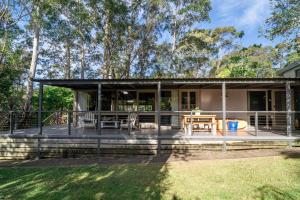 a house with a large deck with a table at Secluded 3-Bed Retreat Moments to the Beach in Surf Beach