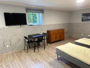 a room with a table and chairs and a tv at HGS Home Noclegi PARKING in Gorzów Wielkopolski